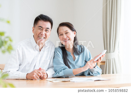 Senior couple turning on household account book Senior couple turning on household account book 105859882