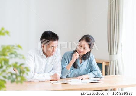 Senior couple turning on household account book Senior couple turning on household account book 105859885