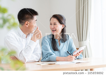 Senior couple turning on household account book Senior couple turning on household account book 105859892