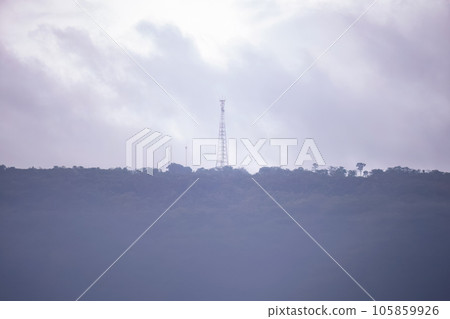 tower in a mountain with forest in the fog 105859926
