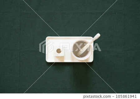Bathroom white toothbrush, cup, holder on green fabric background. top view, copy space Bathroom white toothbrush, cup, holder on green fabric background. top view, copy space 105861941
