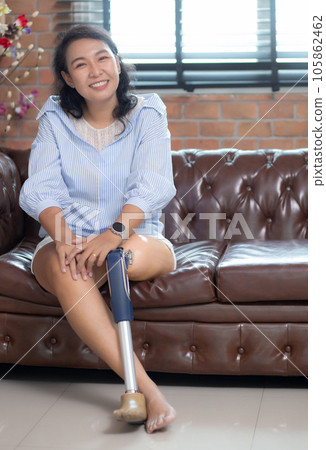 Portrait young asian woman handicapper with leg sitting on sofa for relax in living room. Portrait young asian woman handicapper with leg sitting on sofa for relax in living room. 105862462