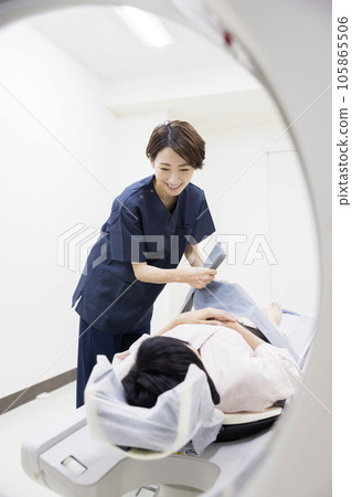 Radiologist and middle female patient preparing for CT examination 105865506