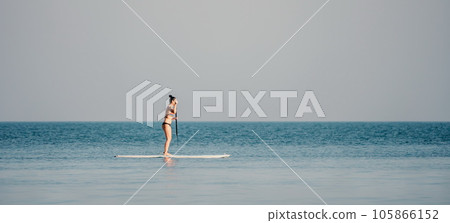 Sea woman sup. Silhouette of happy middle aged woman in rainbow bikini, surfing on SUP board, confident paddling through water surface. Idyllic sunset. Active lifestyle at sea or river. Sea woman sup. Silhouette of happy middle aged woman in rainbow bikini, surfing on SUP board, confident paddling through water surface. Idyllic sunset. Active lifestyle at sea or river. 105866152