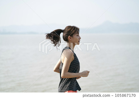 young asian woman female runner running by the sea, black and white 105867170