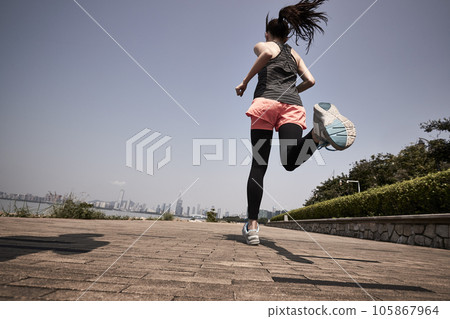 young asian adult woman running jogging outdoors, rear and low angle view 105867964