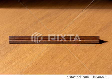 A wooden ruler placed on a wooden board 105868089
