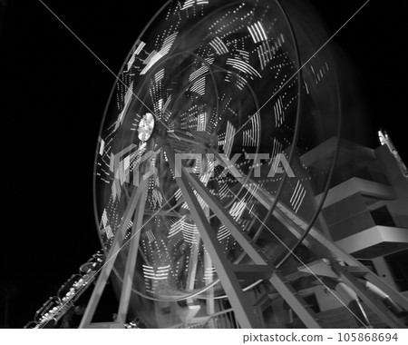 Round ferris wheel spins fast at black night 105868694