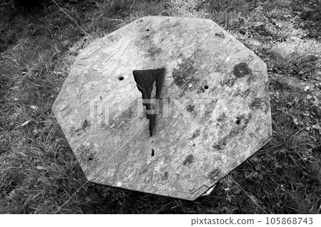 Very old sundial shows time in dense vegetation forest 105868743