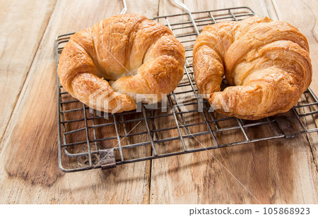 Fresh croissants on old wooden table 105868923