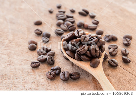 Coffee beans in wooden spoon on wooden background Coffee beans in wooden spoon on wooden background 105869368