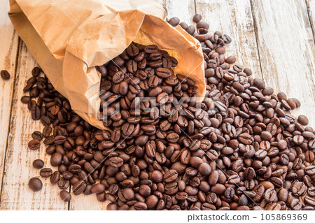 Black coffee beans in paper bag on wooden table Black coffee beans in paper bag on wooden table 105869369
