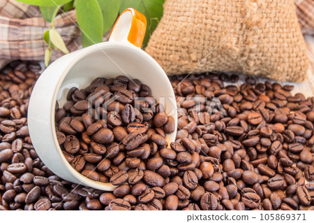 Coffee beans and coffee cup on wooden background Coffee beans and coffee cup on wooden background 105869371