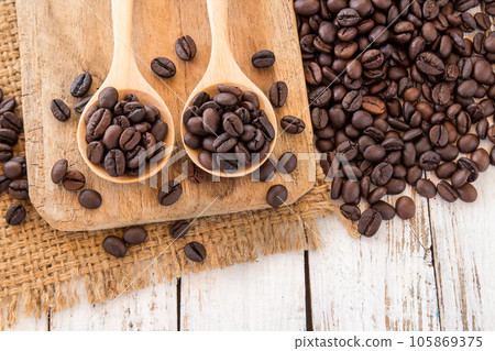 Coffee beans in wooden spoon on wooden background Coffee beans in wooden spoon on wooden background 105869375
