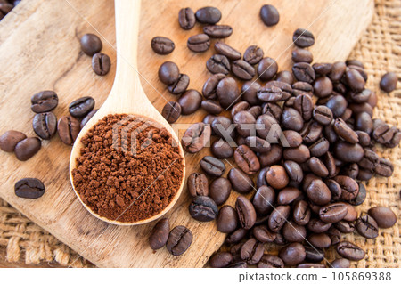 coffee powder in wooden spoon and coffee beans on wooden table 105869388