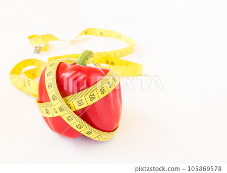 Yellow tape measure and sweet pepper on white background 105869578