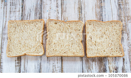 Whole wheat bread on white wooden background 105870086