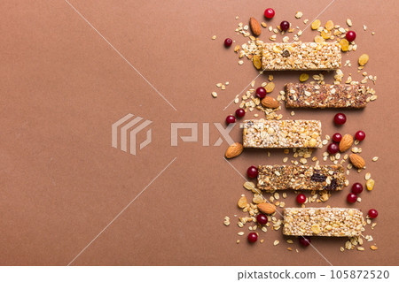 Various granola bars on table background. Cereal granola bars. Superfood breakfast bars with oats, nuts and berries, close up. Superfood concept Various granola bars on table background. Cereal granola bars. Superfood breakfast bars with oats, nuts and berries, close up. Superfood concept 105872520