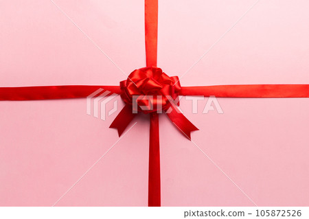 Top view of Red ribbon rolled and red bow isolated on colored background. Flat lay with copy space 105872526