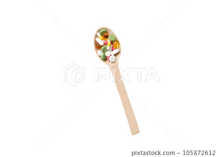 Vitamin capsules in a wooden spoon on a colored background. Pills served as a healthy meal. Drugs, pharmacy, medicine or medical healthycare concept 105872612