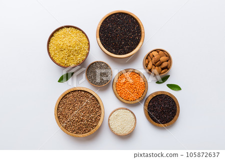 Various superfoods in smal bowl on colored background. Superfood as rice, chia, quinoa, lentils, nuts, sesame seeds, almonds. top view copy space Various superfoods in smal bowl on colored background. Superfood as rice, chia, quinoa, lentils, nuts, sesame seeds, almonds. top view copy space 105872637