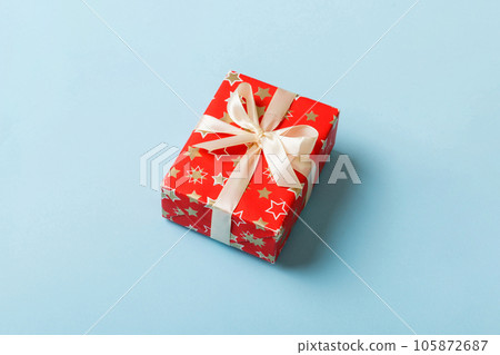 Wrapped christmas or other holiday handmade present in paper with colored ribbon. Present box, decoration of gift on table, top view with copy space 105872687