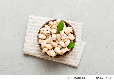 Fresh healthy Pistachios in bowl on colored table background. Top view Healthy eating concept. Super foods 105872694