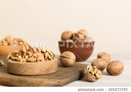Fresh healthy walnuts in bowl on colored table background. Top view Healthy eating bertholletia concept. Super foods 105872705