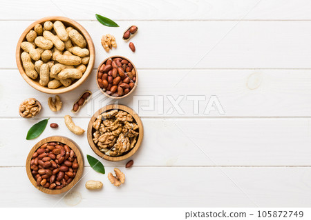 Walnut kernel halves, in a wooden bowl. Close-up, from above on colored background. Healthy eating Walnut concept. Super foods with copy space 105872749