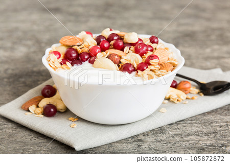 Healthy breakfast food with granola, yogurt, fruits and nuts. Dessert parfait with dried fruits for breakfast 105872872