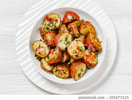 Herbs Garlic Potatoes in white bowl, top view Herbs Garlic Potatoes in white bowl, top view 105873325