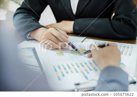 Two business leaders talk about charts, financial graphs showing results are analyzing and calculating planning strategies, business success building processes 105873622