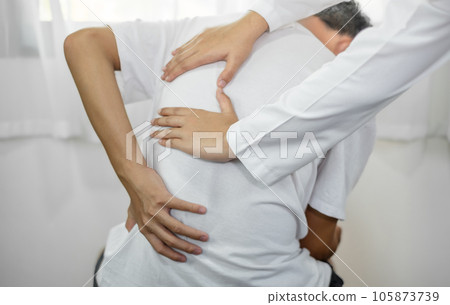 Female physiotherapists provide physical assistance to male patients with back injuries back massages for relaxation and muscle recovery in the rehabilitation center 105873739