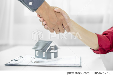 Businessmen and brokers real estate agents shake hands after completing negotiations to buy house insurance and sign contracts. Home insurance concept 105873769