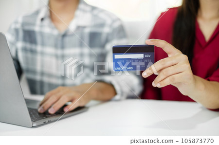 E-commerce Concept. Happy couple holding credit card enjoying doing online shopping and using laptop enter their card number in-app to purchase and payment in internet store 105873770
