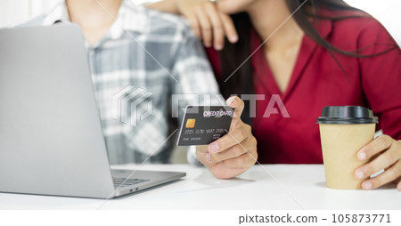 E-commerce Concept. Happy couple holding credit card enjoying doing online shopping and using laptop enter their card number in-app to purchase and payment in internet store 105873771