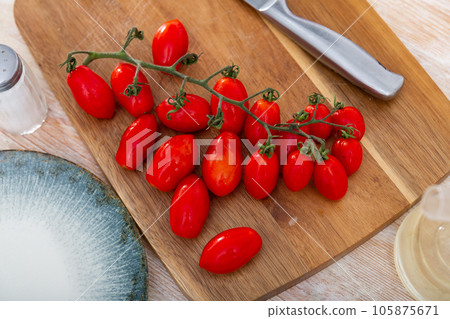 Cutting board with ripe cherry tomatoes and knife 105875671