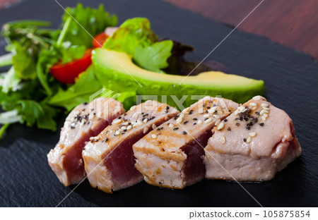 Delicious raw tuna fish served with fresh avocado and greens Delicious raw tuna fish served with fresh avocado and greens 105875854