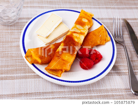 Pancakes with honey, raspberries and slices of cheese Pancakes with honey, raspberries and slices of cheese 105875879