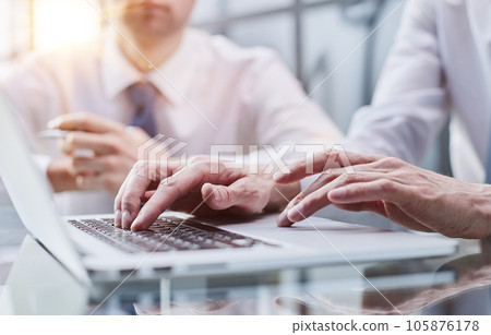 Closeup view of two young coworkers working on mobile laptop computer at office 105876178
