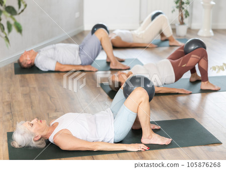Group of elderly people doing pilates with soft ball in studio 105876268