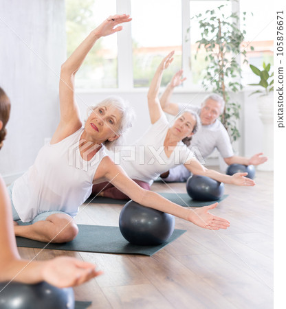 Group of elderly people doing pilates with soft ball in studio 105876671