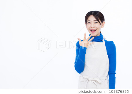 A housewife in her thirties who is surprised with a smile in front of a white background 105876855