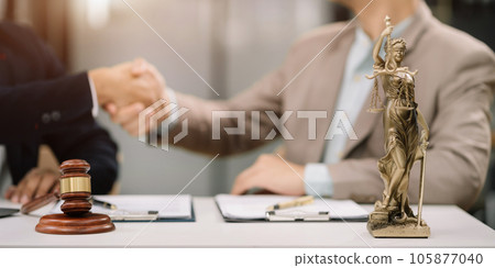 Middle age partner lawyers attorneys shaking hands after discussing a contract agreement done. Middle age partner lawyers attorneys shaking hands after discussing a contract agreement done. 105877040