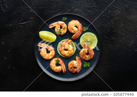 Shrimps, overhead flat lay shot on black. Cooked shrimp with lime 105877440