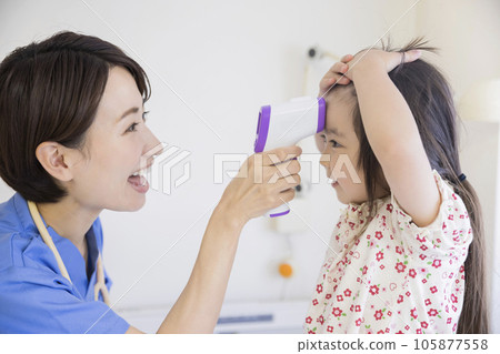 A female nurse measuring a child's fever with a non-contact thermometer 105877558