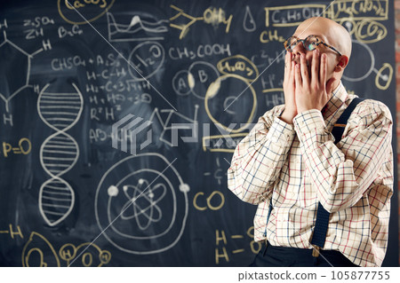 Young man, scientist feeling sad and stressful about unsuccessful researches. Formulas on blackboard 105877755