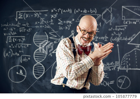 Excited and emotional scientist, teacher expressing feeling, finding out solution. Formulas and calculations on blackboard Excited and emotional scientist, teacher expressing feeling, finding out solution. Formulas and calculations on blackboard 105877779
