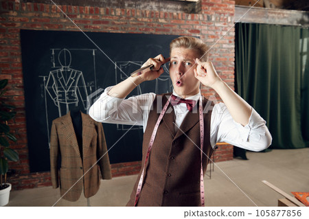 Young man, fashion designer with emotional face, generating new clothing collection ideas. Creative thinking 105877856