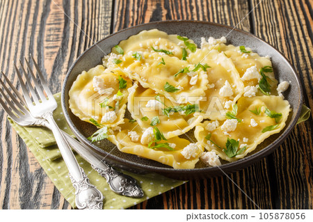 Crescent mezzaluna pasta stuffed with soft goat cheese and herbs close-up in a plate. Horizontal Crescent mezzaluna pasta stuffed with soft goat cheese and herbs close-up in a plate. Horizontal 105878056